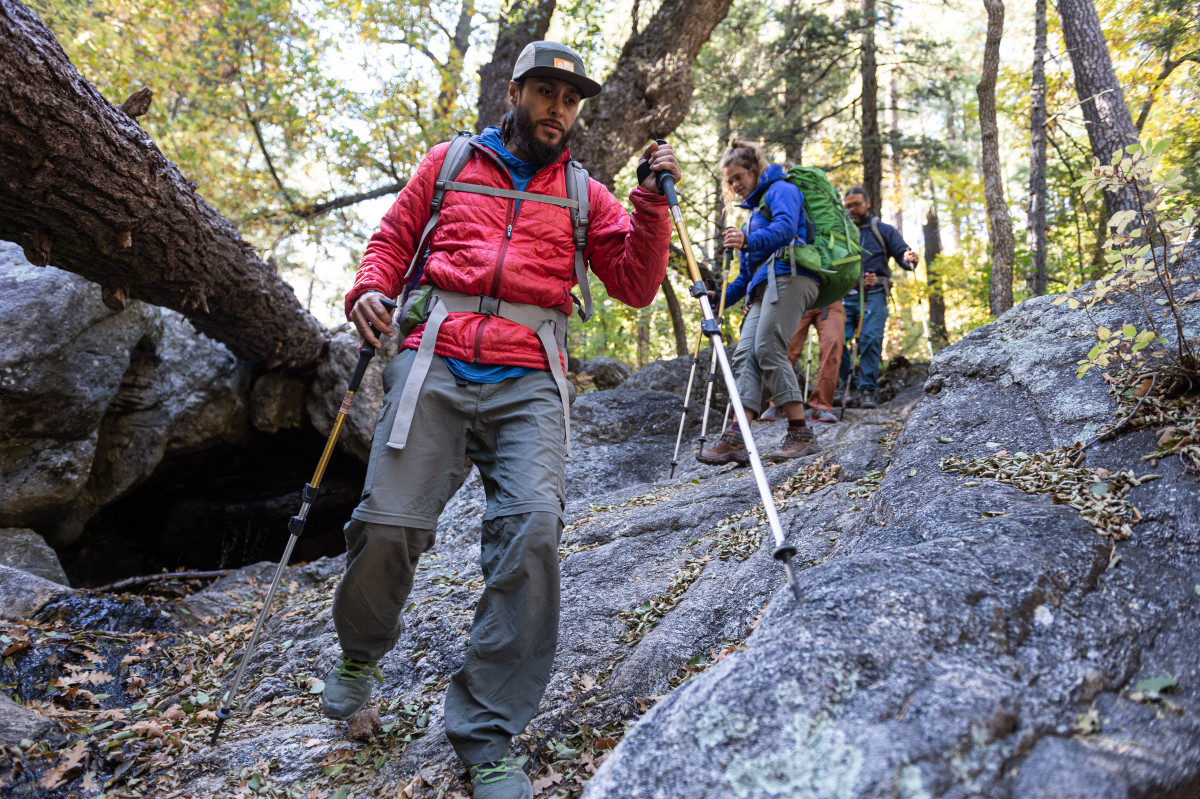 People hiking downhill with trekking poles