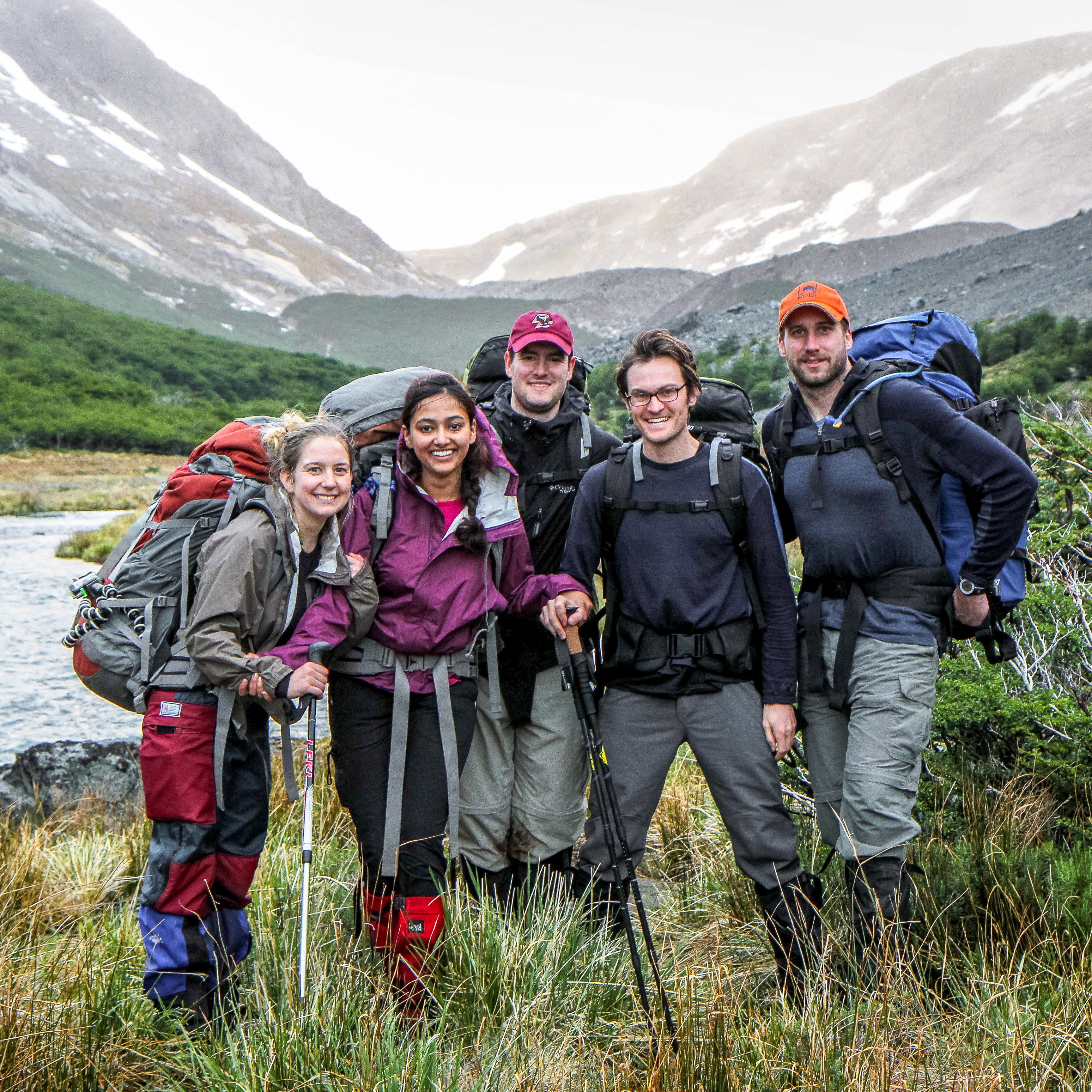 Group of five NOLS gap year students with hiking and backpacking gear among a beautiful landscape.