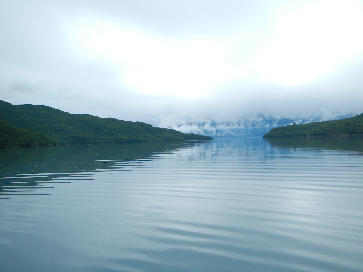 Calm waters with fog and mountains