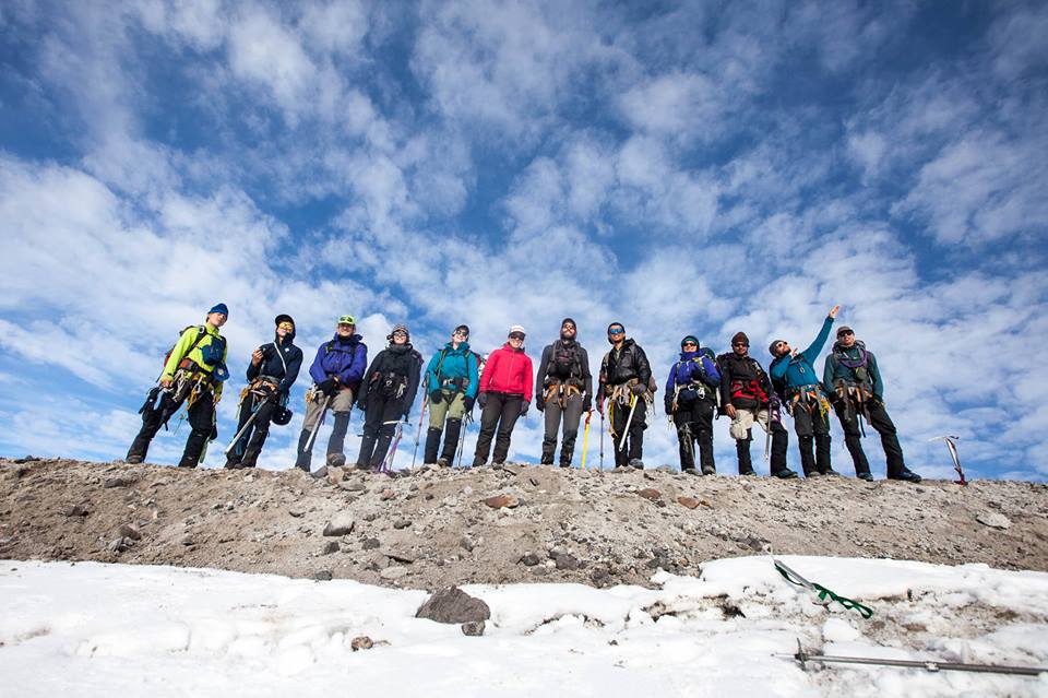 Group stands in a line on a rocky ridge