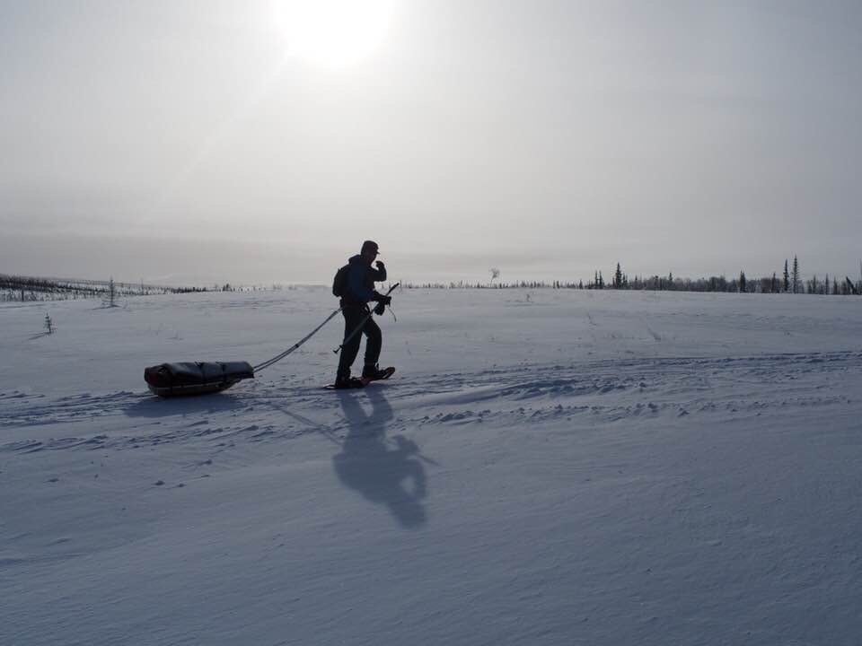 Pete Ripmaster pulls a sled across a snowy Alaskan landscape