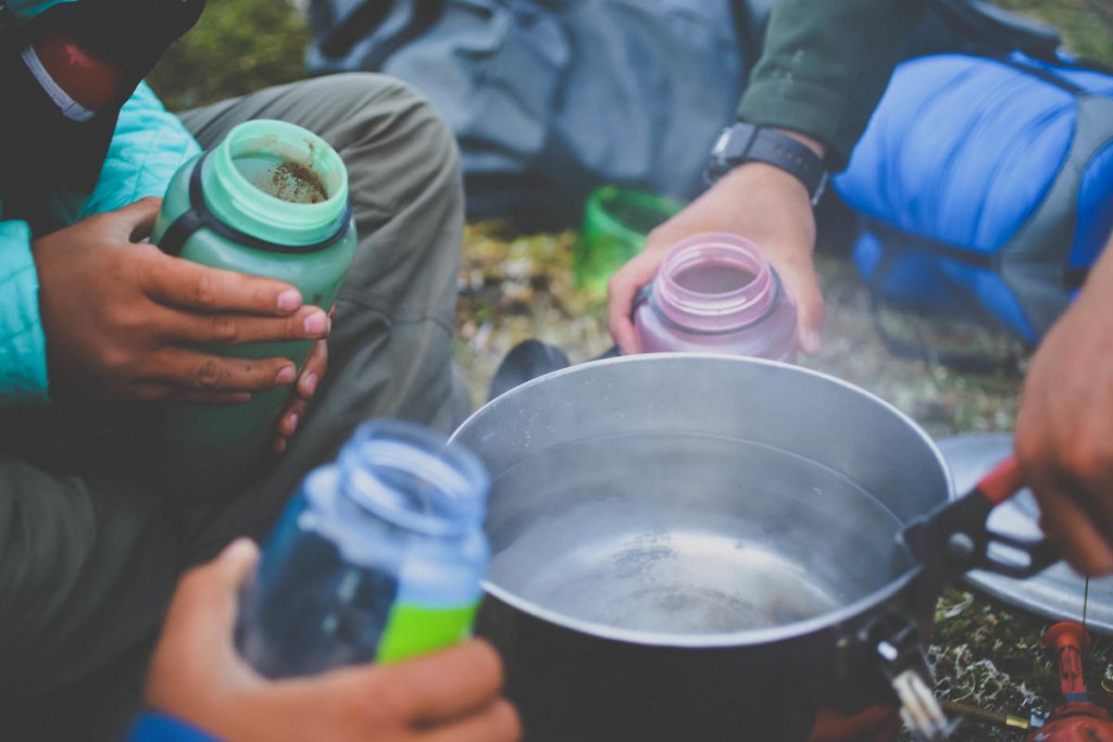 Close up of open water bottles around a boiling pot of water