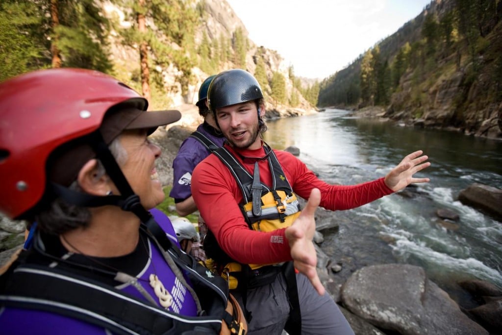 People talking while wearing river paddling equipment