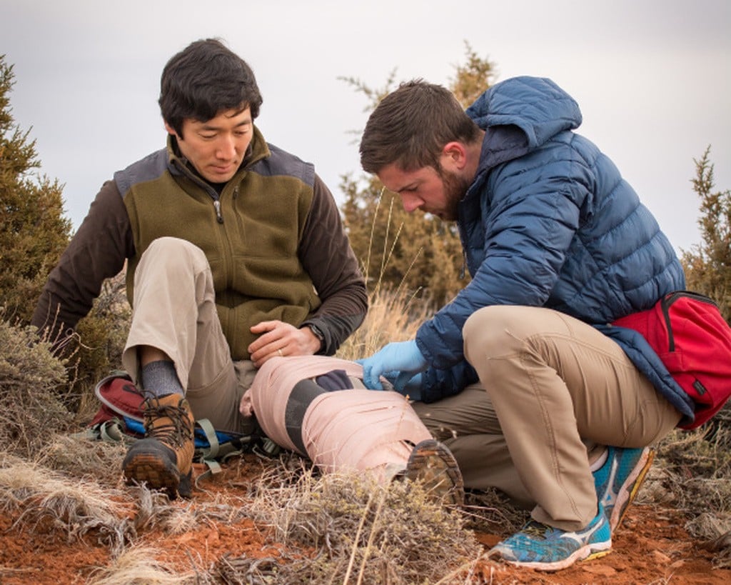 First responder creating an improvised splint in a practice scenario