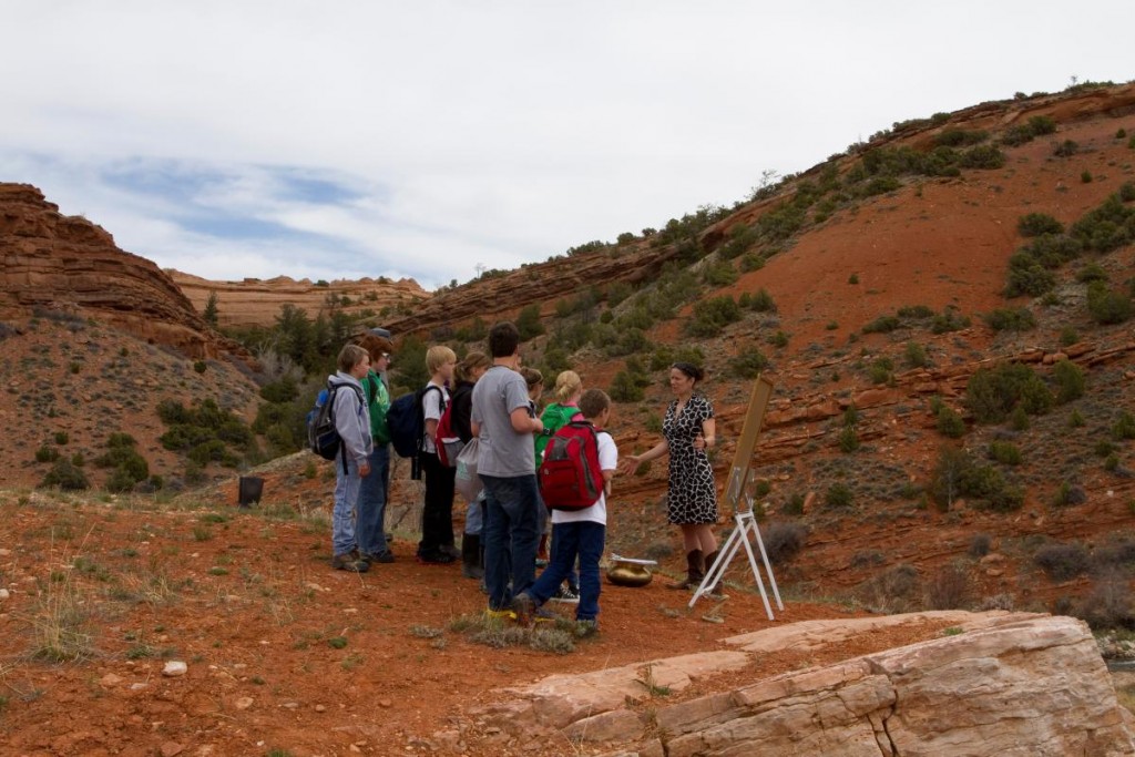 woman teaches schoolchildren outdoors in a red rock canyon