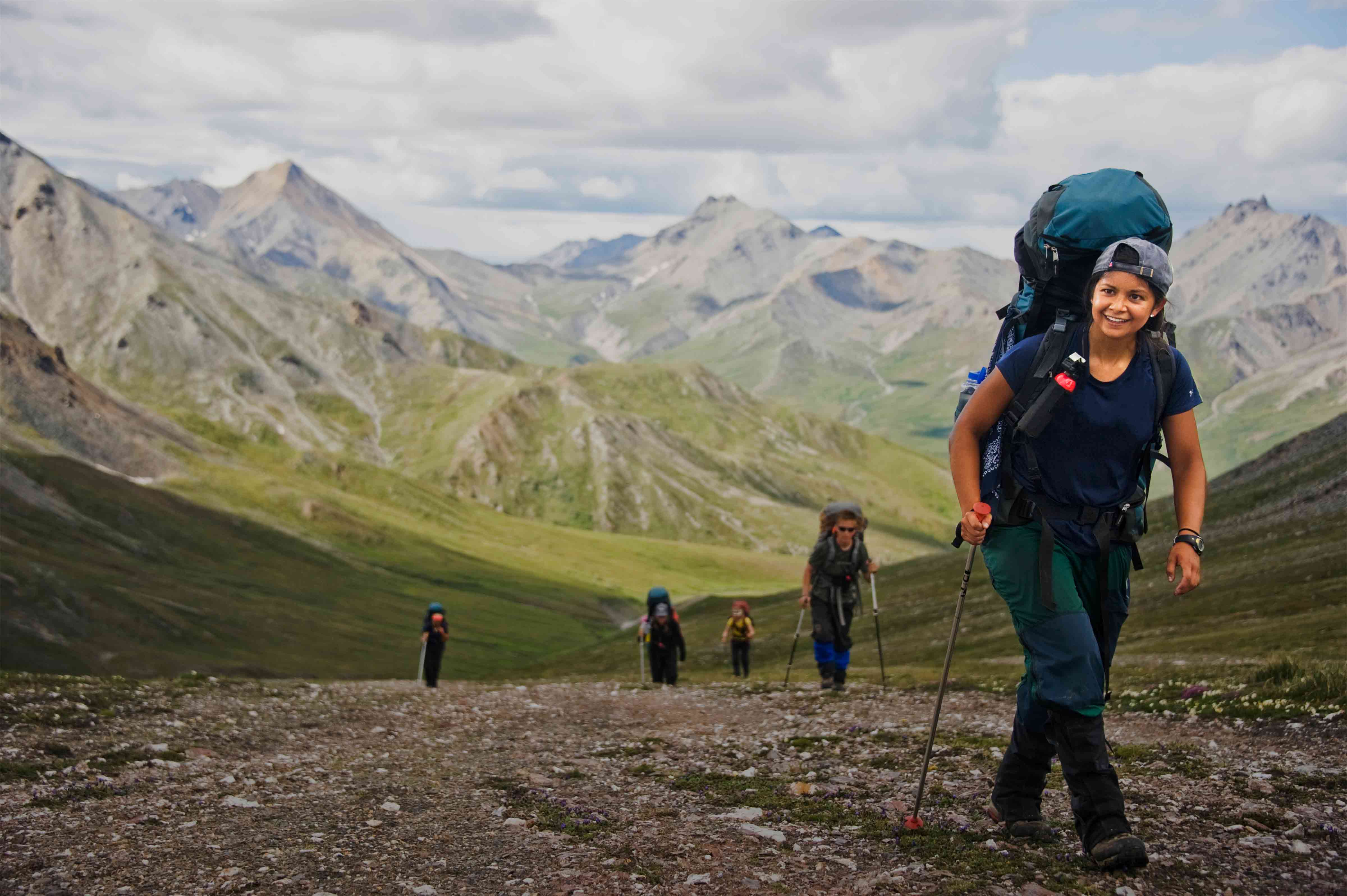 Happy person backpacking in Alaska with a group of peers