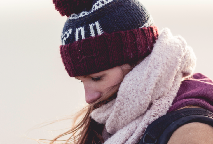 Woman wearing scarf pulled up to nose and beanie hat